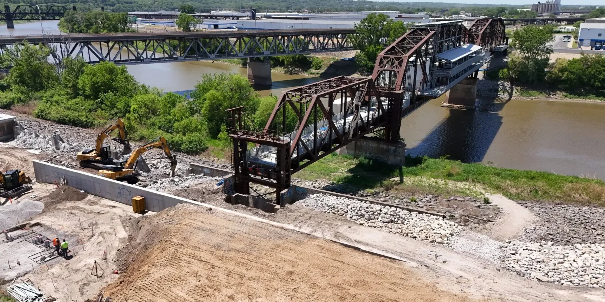 Rusty steel swing bridge over muddy river